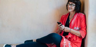 Woman Sitting on bench with phone.