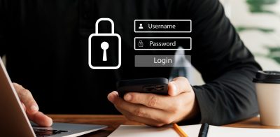 Person typing on laptop and holding phone with login hologram displayed. Concept of cybersecurity and login and password and secure Internet access.